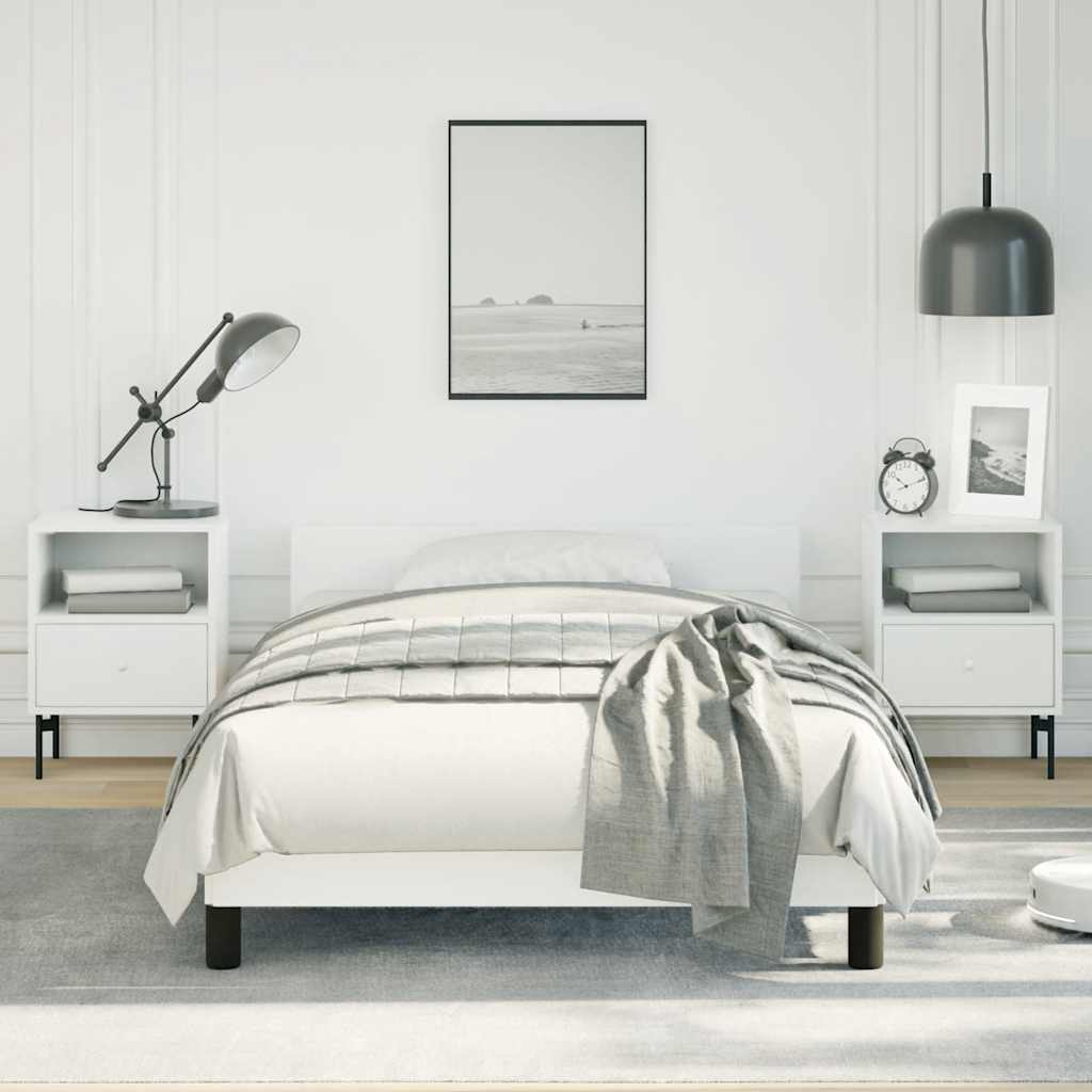 Minimalist white bed frame with a grey striped comforter and matching throw blanket
