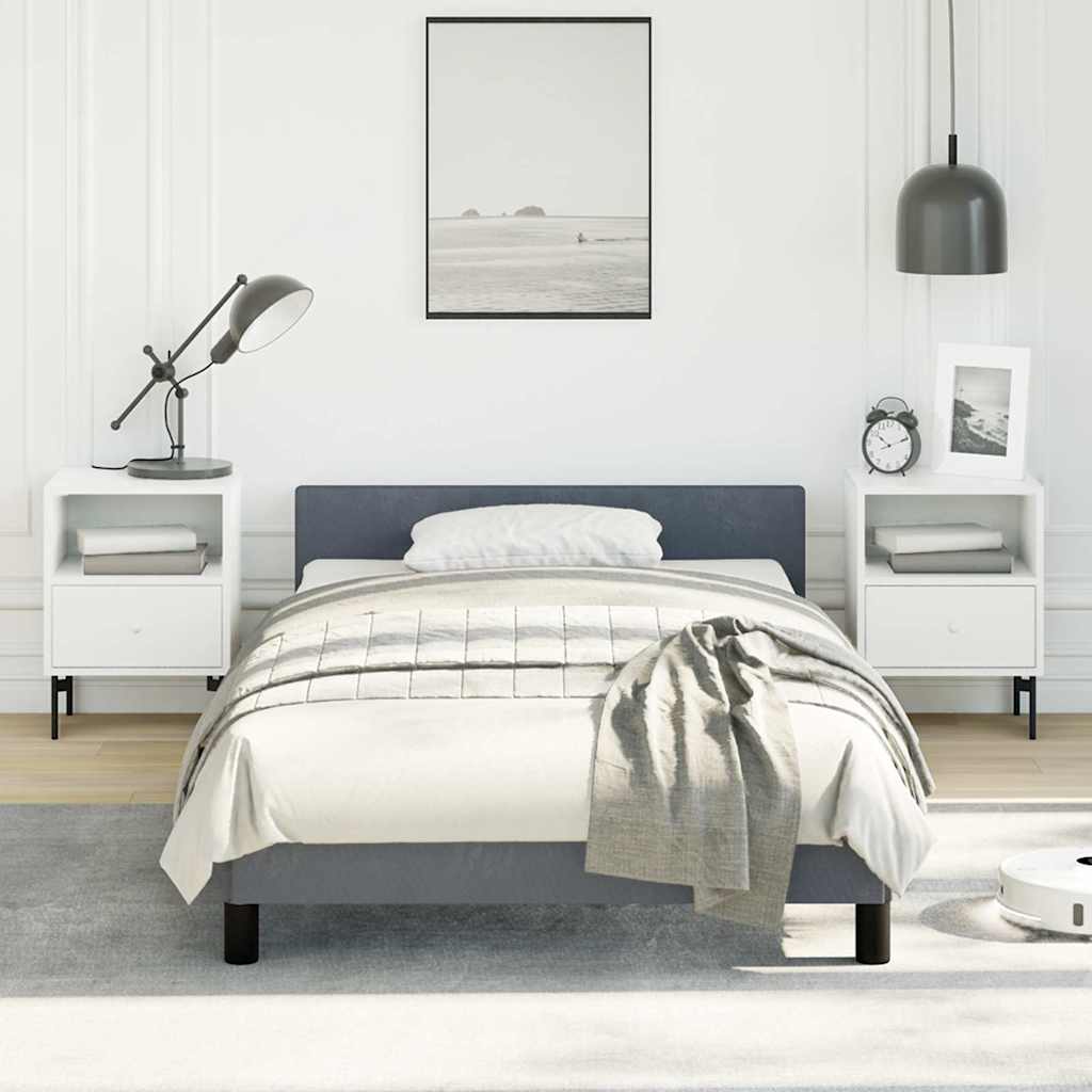 A minimalist gray upholstered twin bed with a white duvet and gray throw blanket