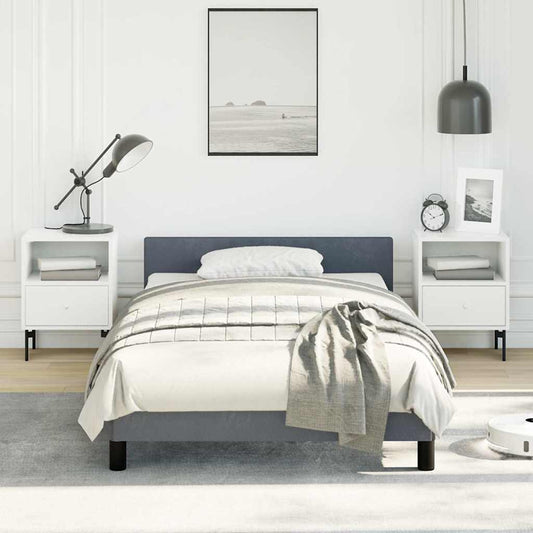 A minimalist gray upholstered twin bed with a white duvet and gray throw blanket