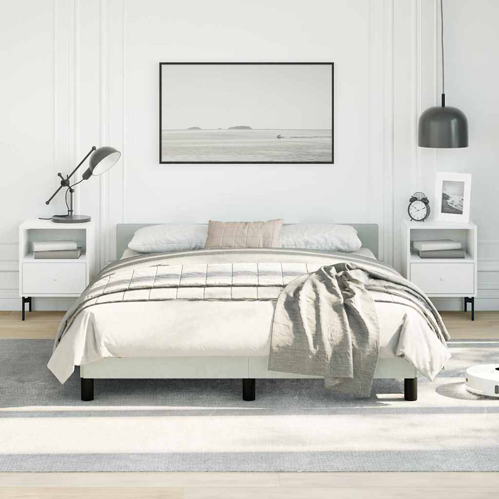 White upholstered platform bed with grey striped comforter and matching throw blanket