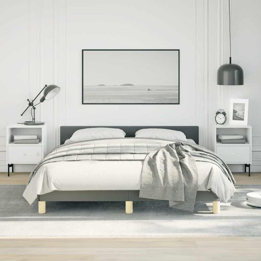 Modern grey upholstered platform bed with light wood legs and white bedding