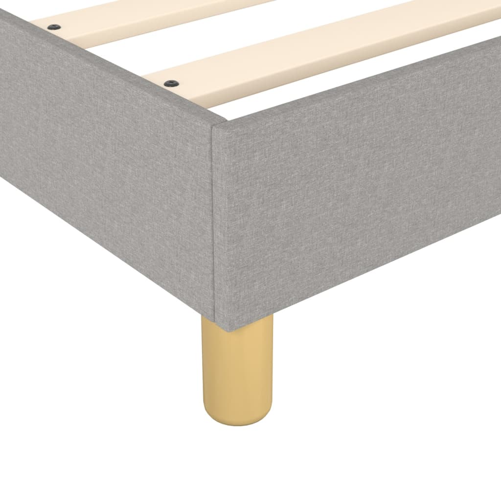 Grey upholstered platform bed frame with wooden slats and short wooden legs