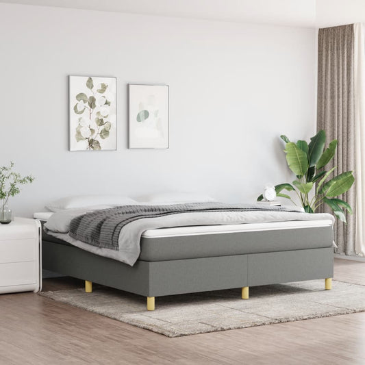 Gray upholstered divan bed with a quilted mattress and wooden legs