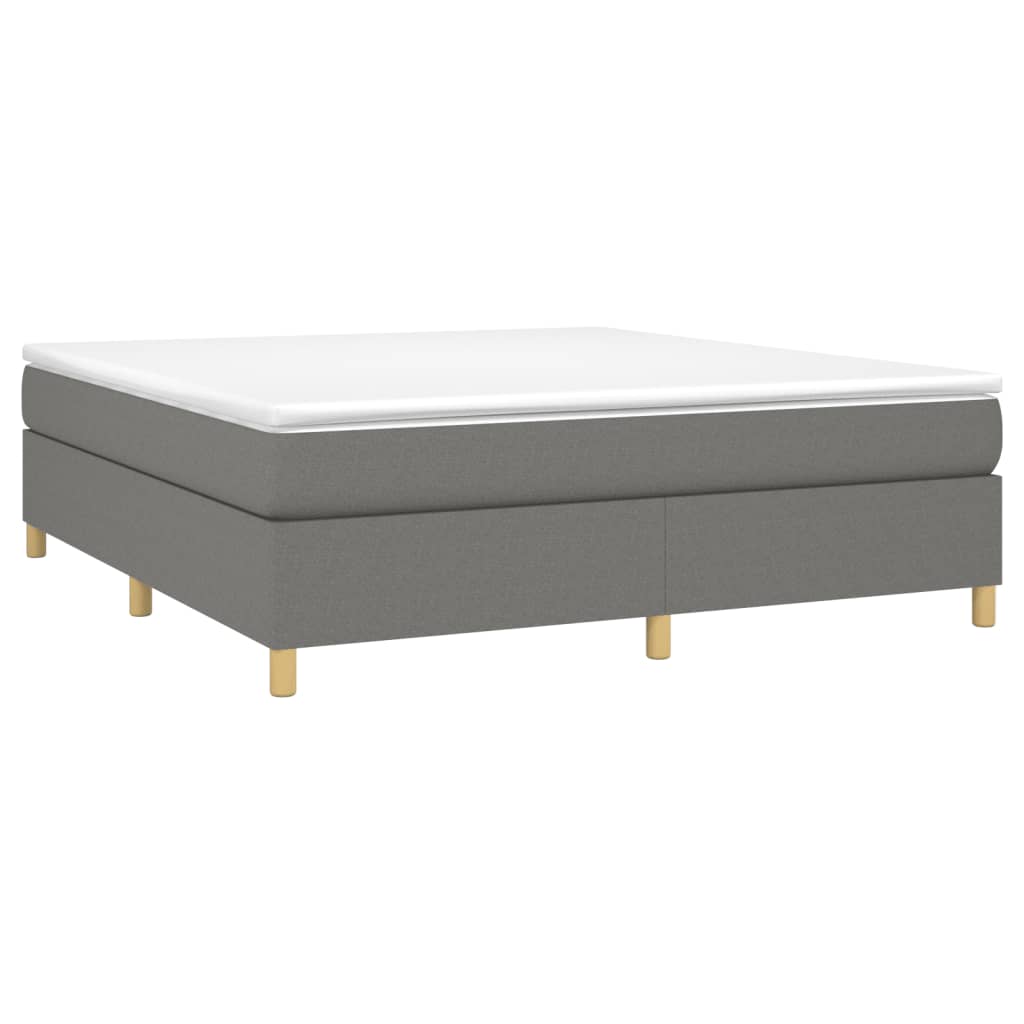 Grey upholstered divan bed base with white mattress topper and wooden legs