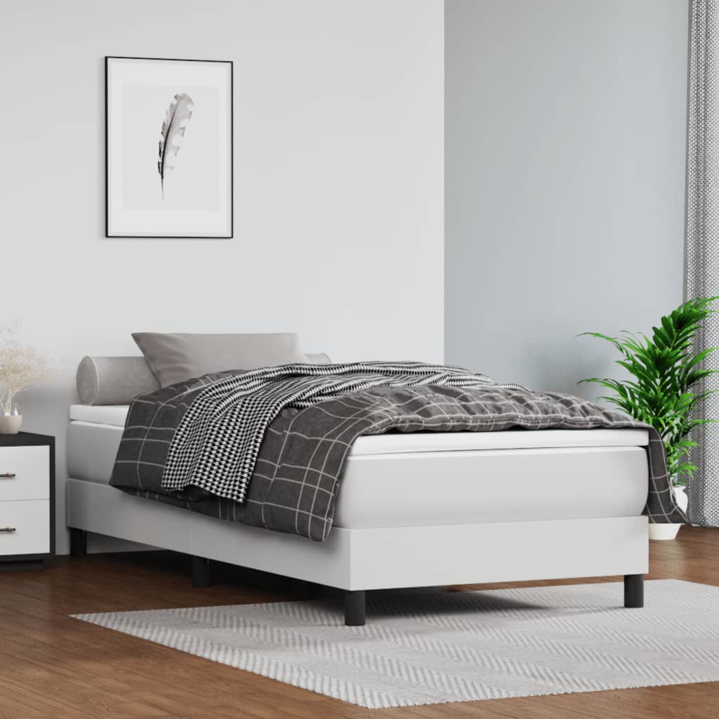 White upholstered bed frame with checkered duvet and grey pillows