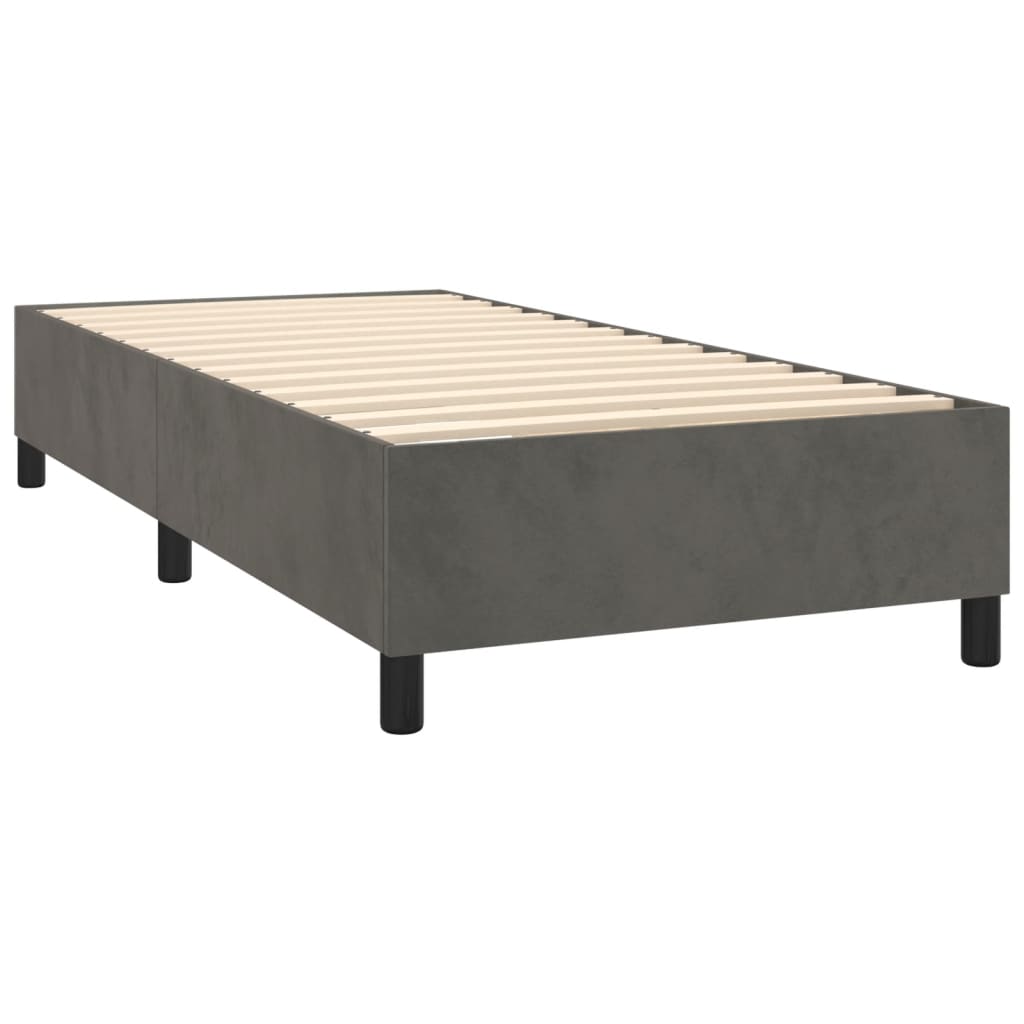 Gray upholstered divan bed with a white mattress topper