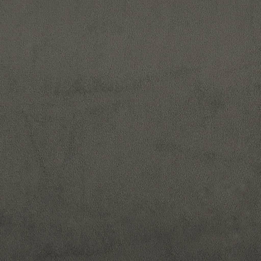 Closeup of a dark gray upholstered bed frame corner with black cylindrical legs
