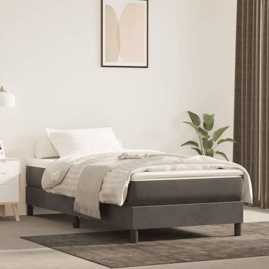 Dark grey upholstered single bed frame with white bedding and a woven throw