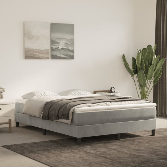 Grey upholstered bed frame with white bedding and a grey throw blanket