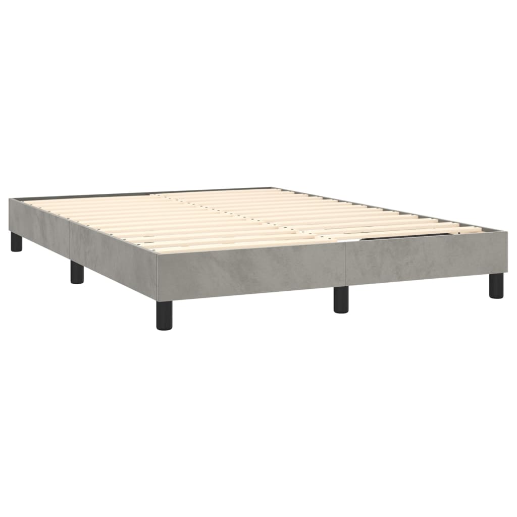 Grey upholstered divan bed base with white mattress and black legs