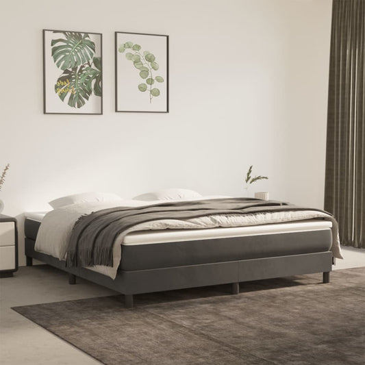 Dark grey upholstered platform bed frame with white linens and a textured throw blanket