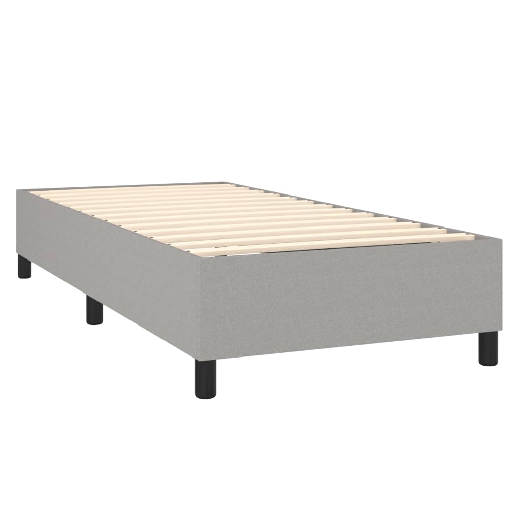 Grey upholstered single divan bed with white mattress topper