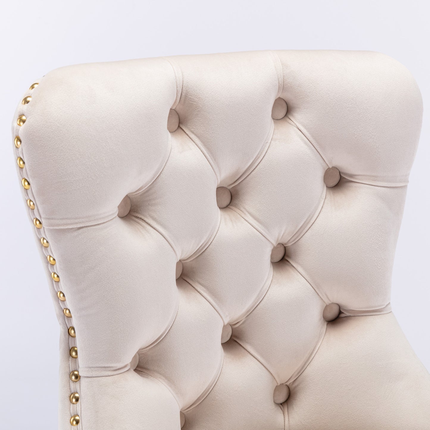 Cream velvet armchair with tufted backrest and gold nailhead trim detail