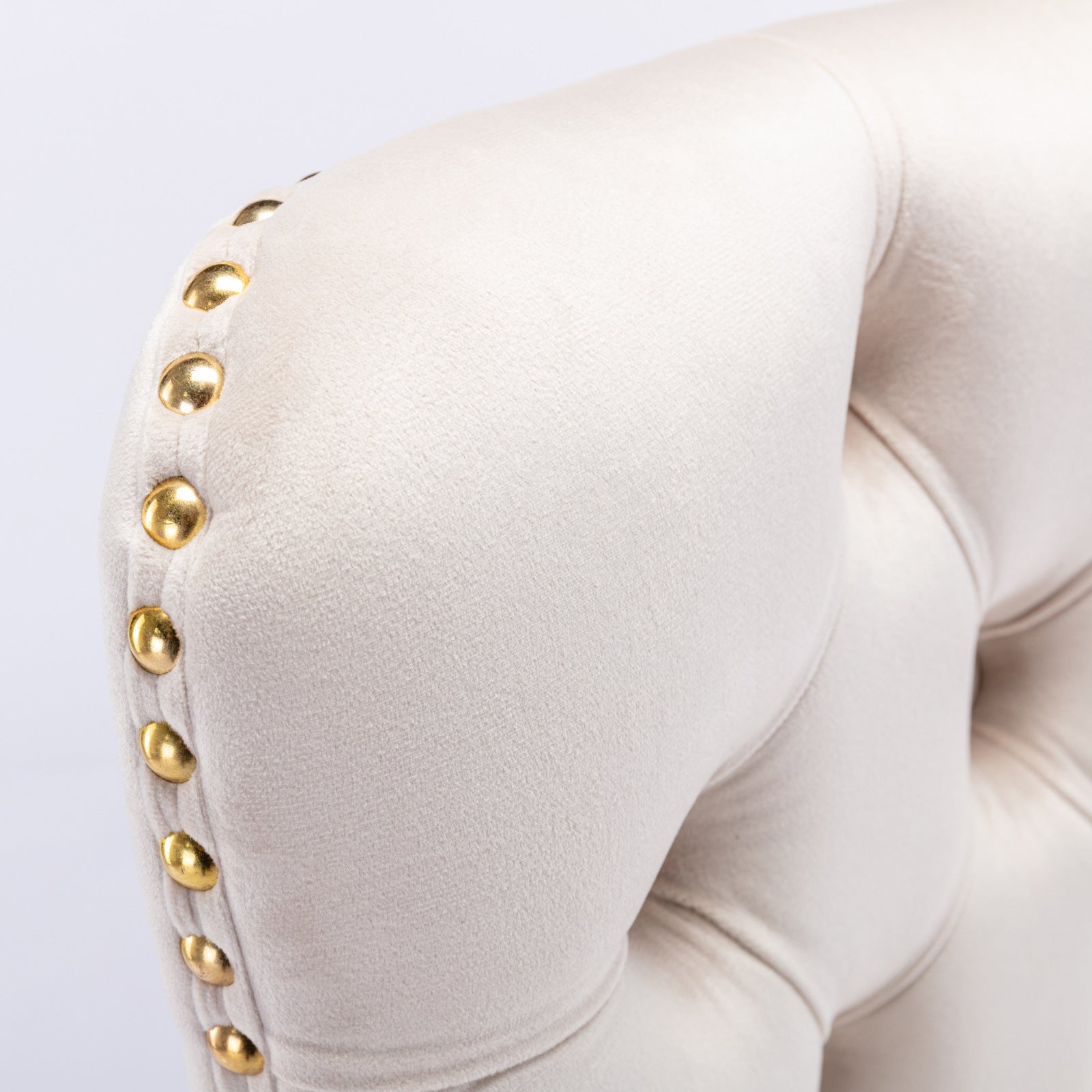 Cream velvet armchair with gold nailhead trim detail