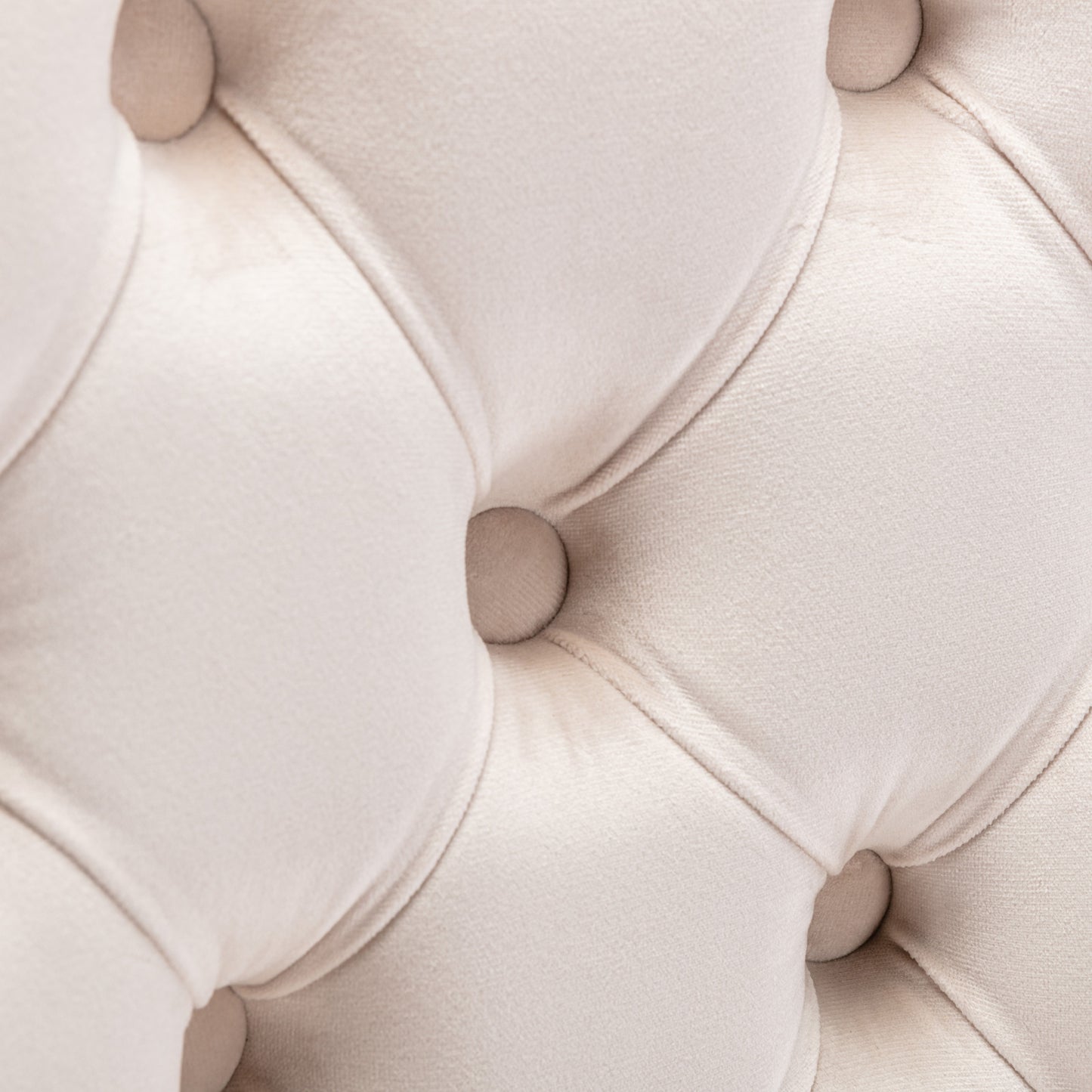 Closeup of ivory velvet tufted sofa fabric with deep button details