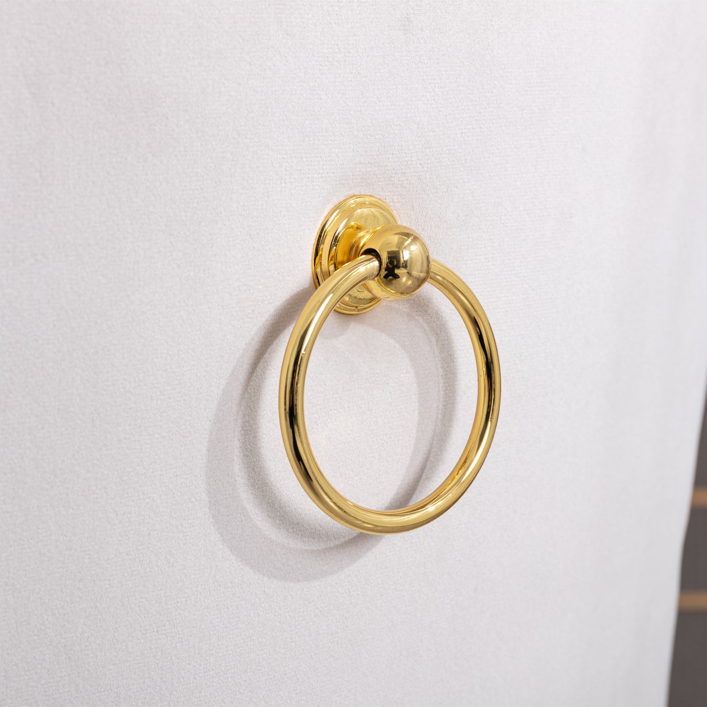 Gold ring pull hardware on white textured cabinet door