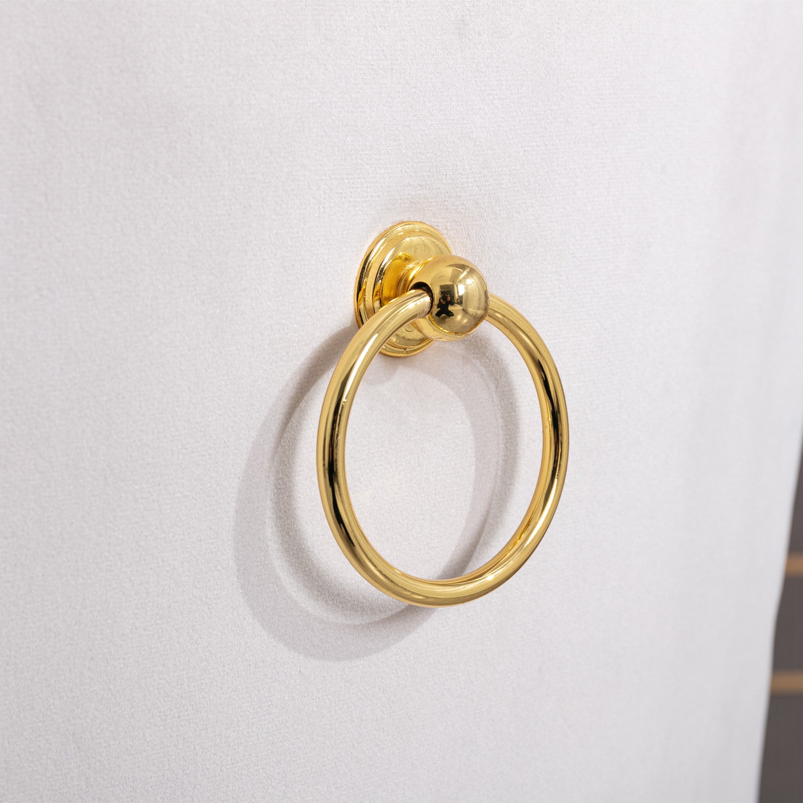 Gold ring pull hardware on white textured cabinet door