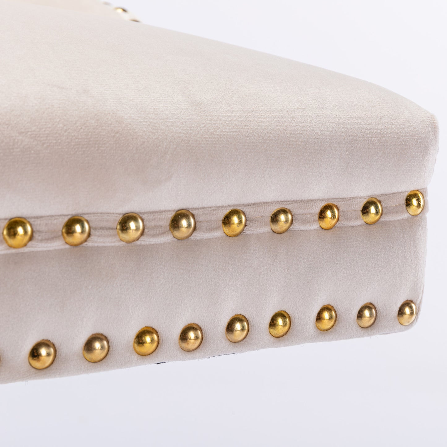 Light beige velvet ottoman with gold nailhead trim