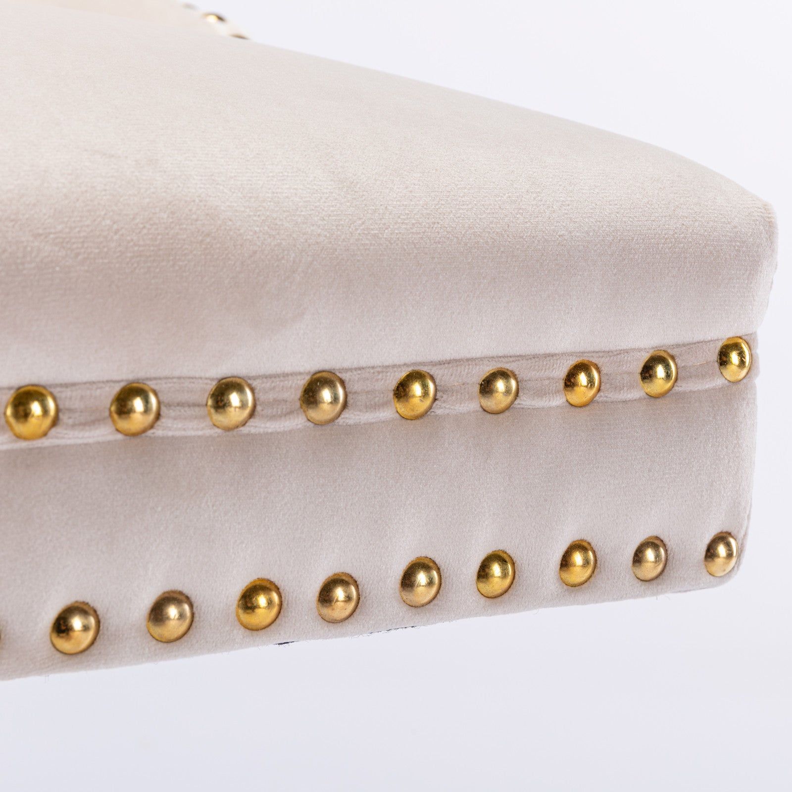 Light beige velvet ottoman with gold nailhead trim