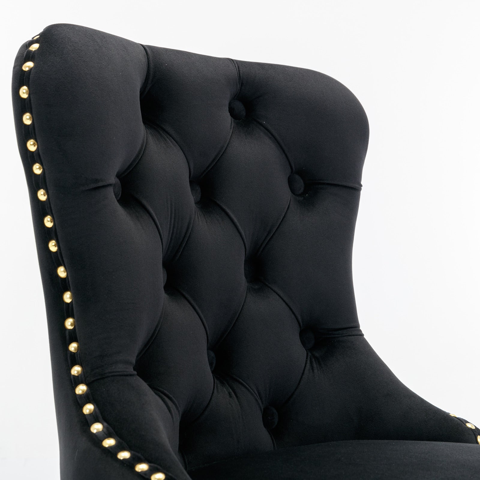 Black velvet armchair with tufted back and gold nailhead trim accents