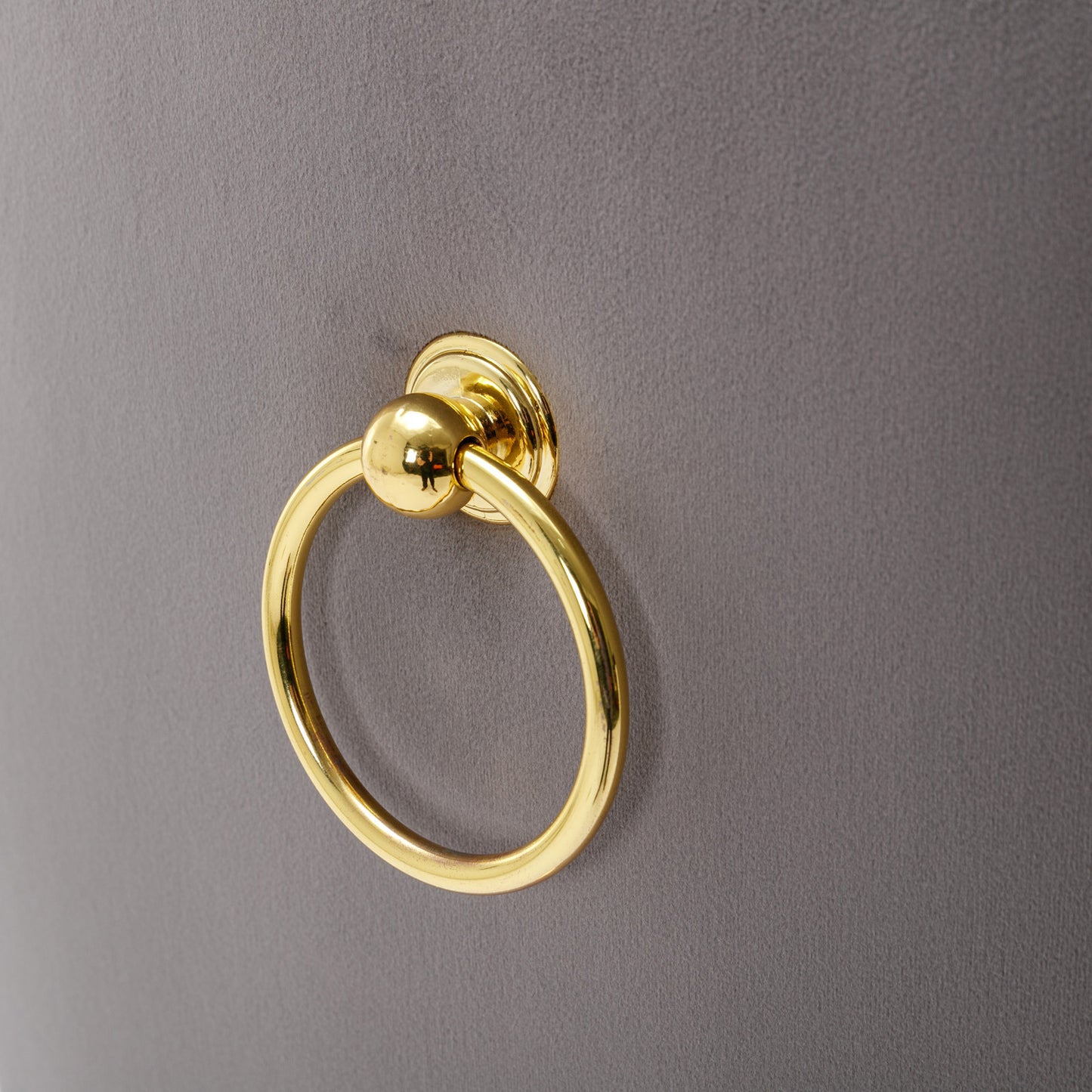 Gold ring pull on a gray velvet accent chair
