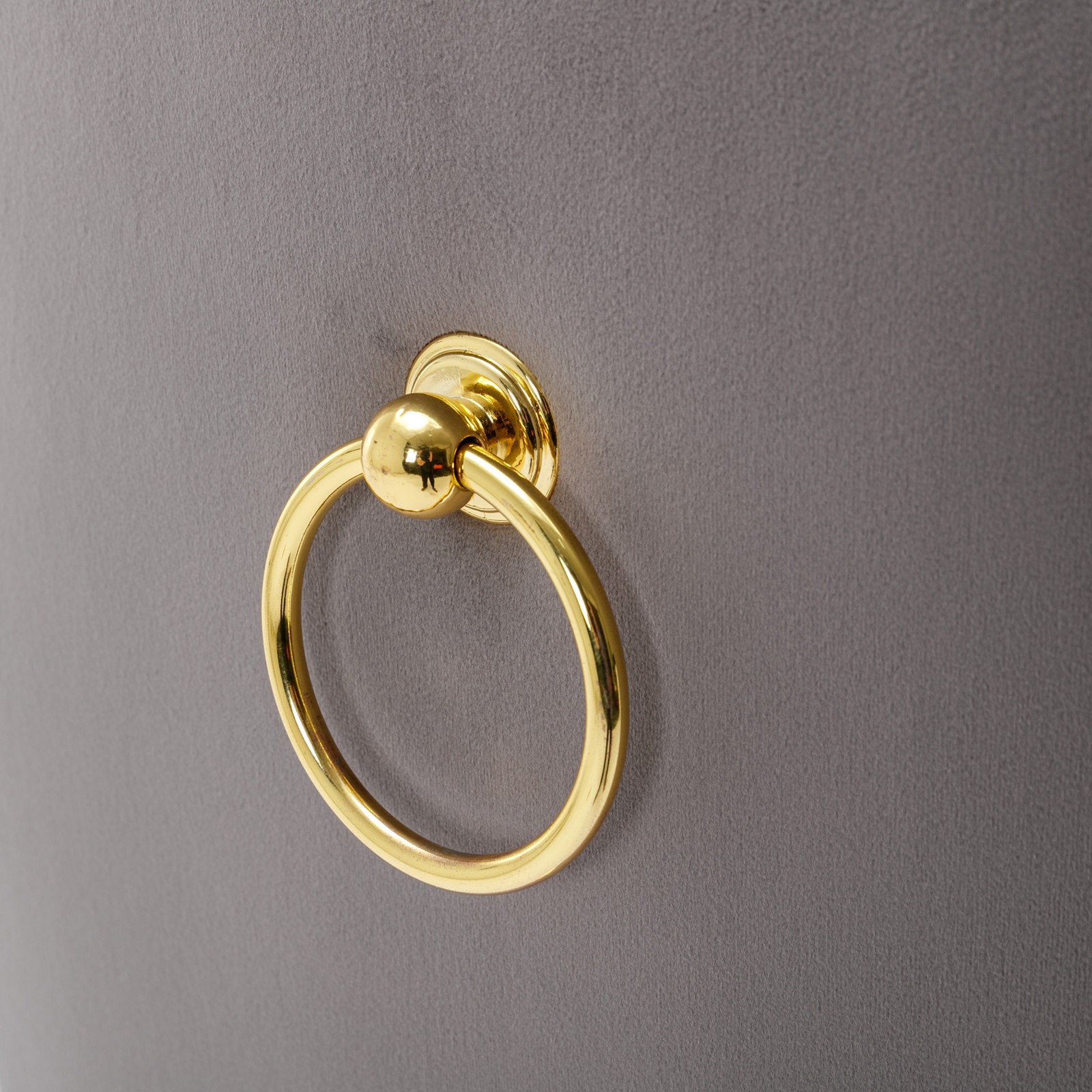 Gold ring pull on a gray velvet accent chair