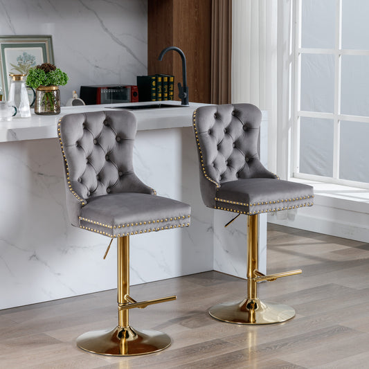 Grey velvet bar stools with tufted backs and gold accents