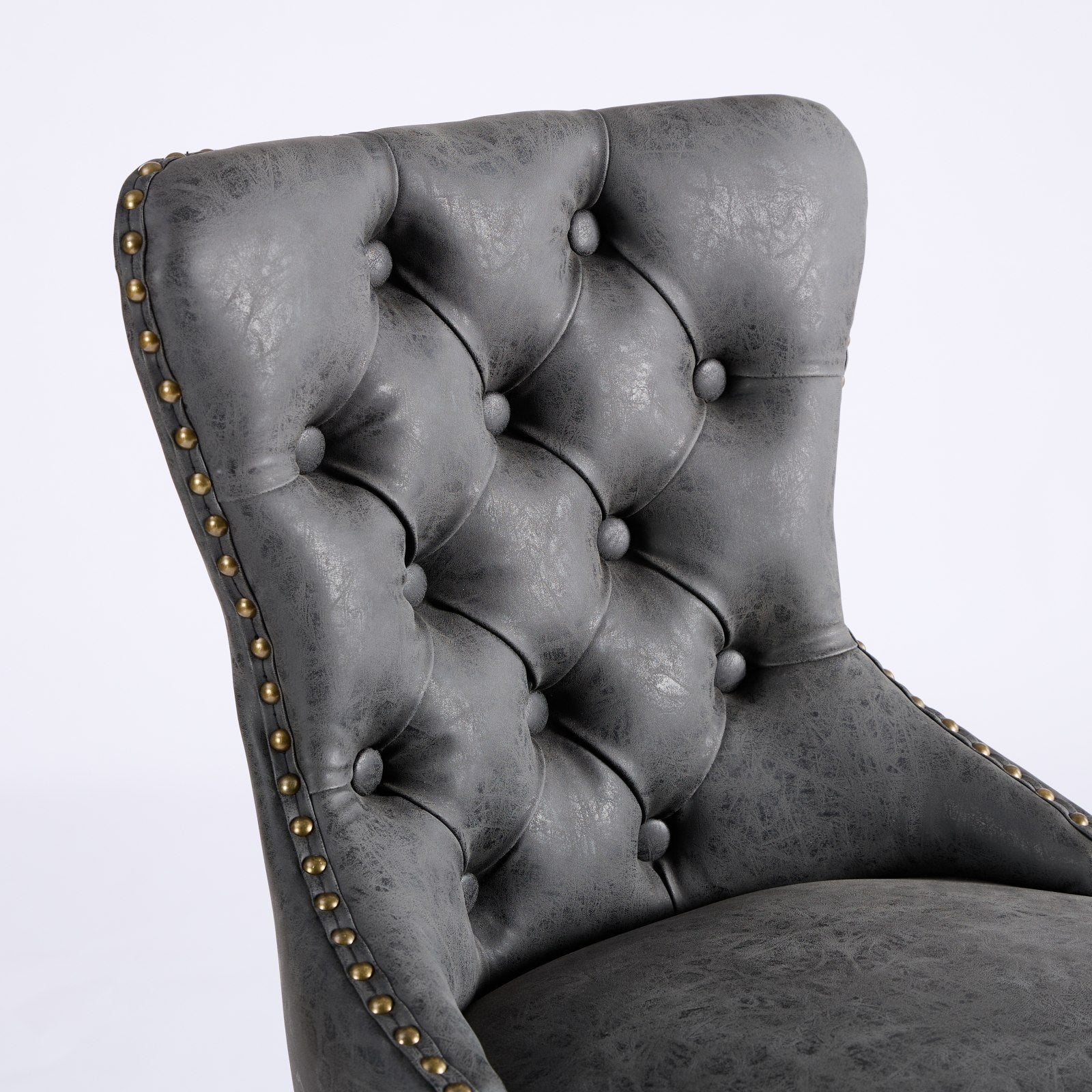 Dark grey tufted faux leather accent chair with brass nailhead trim