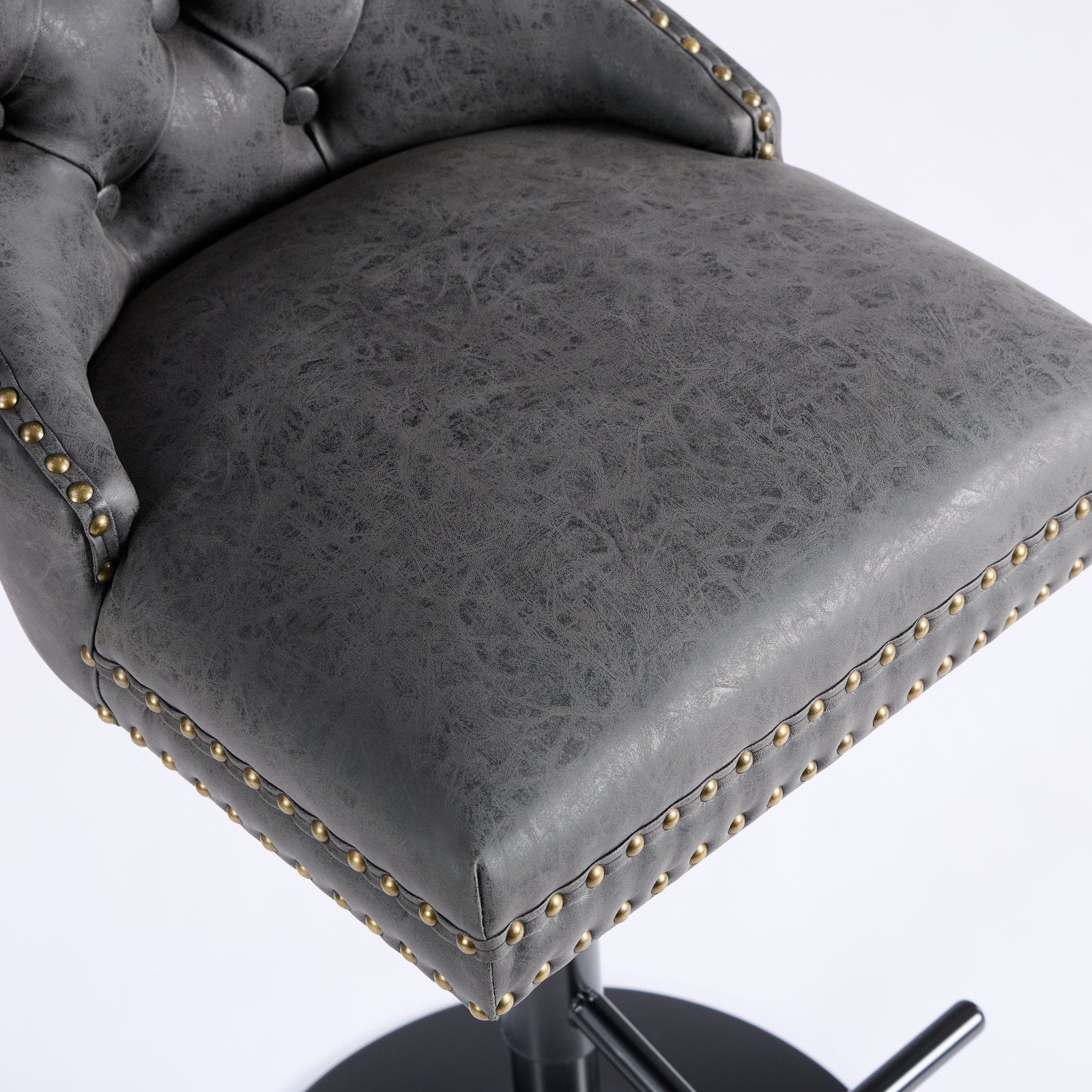 Gray tufted faux leather bar stool with antique brass nailhead trim