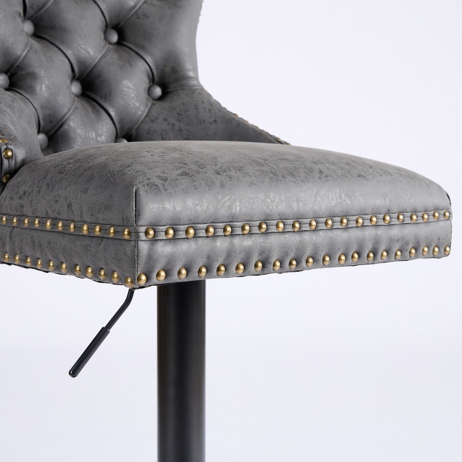 Grey faux leather tufted bar stool with brass nailhead trim