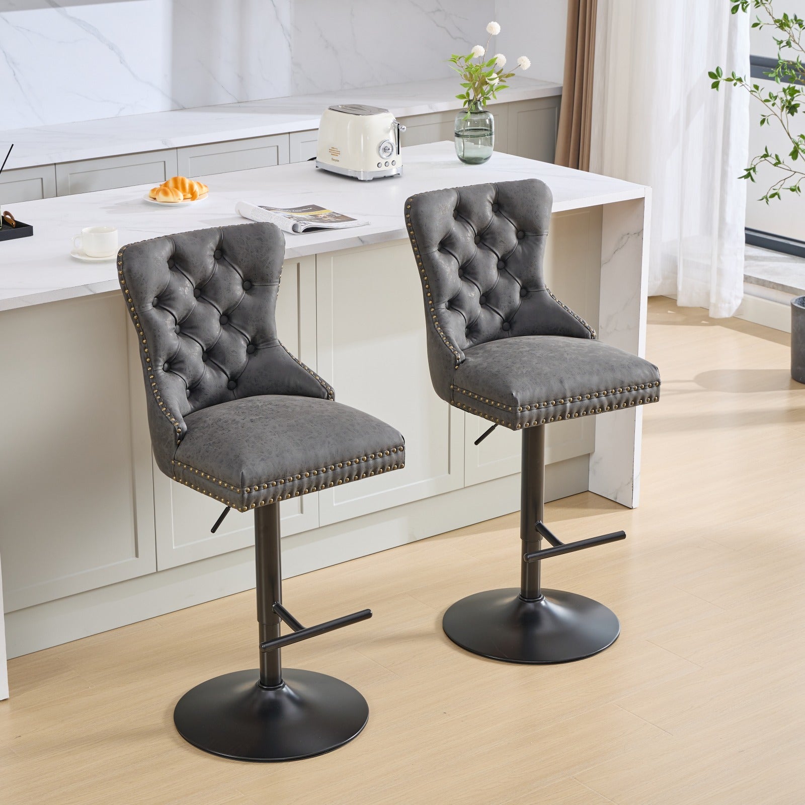 Tufted grey leather bar stool with gold nailhead trim and adjustable height