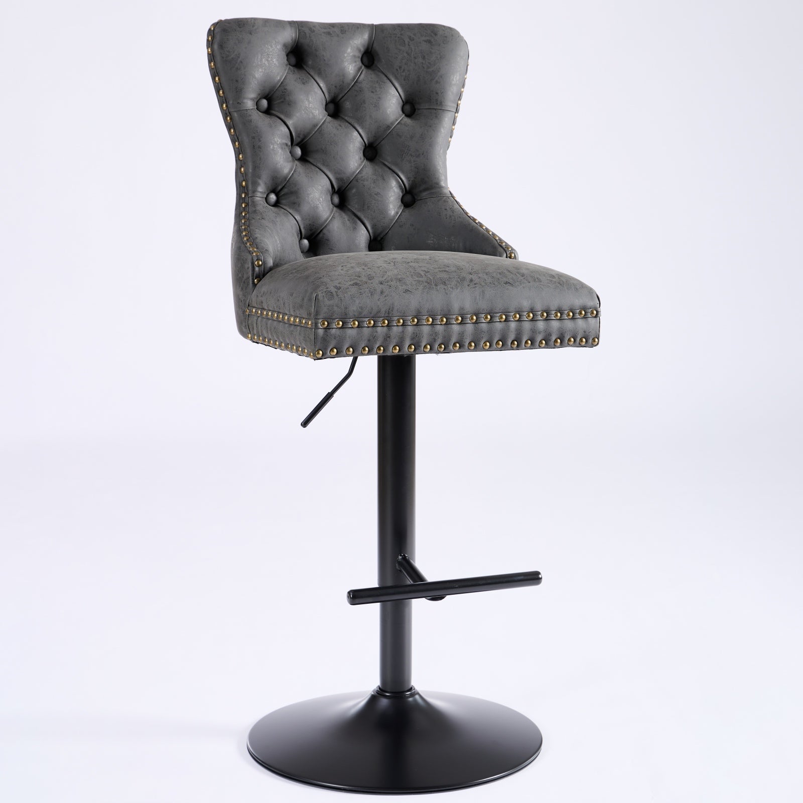 Grey tufted faux leather bar stool with brass nailhead trim and adjustable height