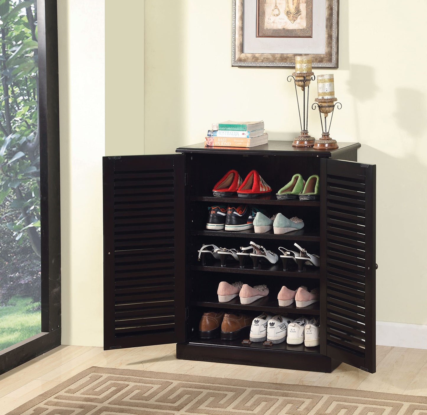 Dark brown louvered shoe cabinet filled with various shoes like red slippers and sneakers