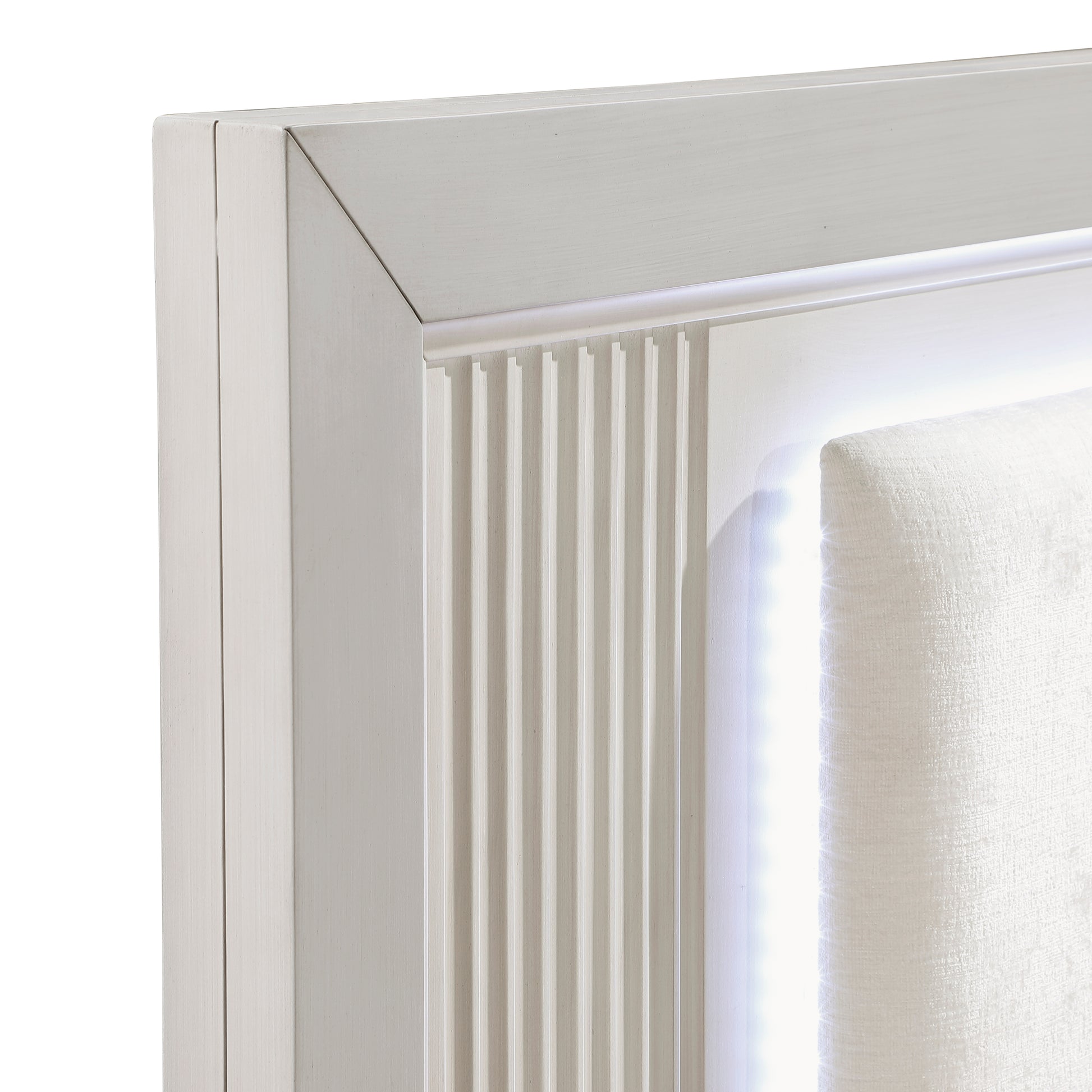 Closeup of a modern white headboard with ribbed wood detail and integrated LED lighting