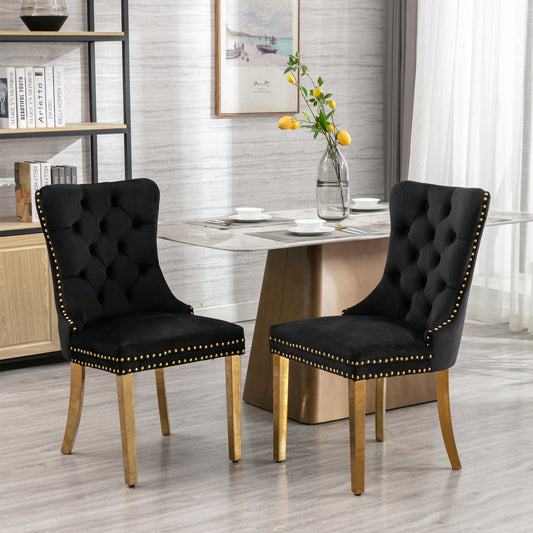 Black velvet dining chair with tufted back and gold nailhead trim