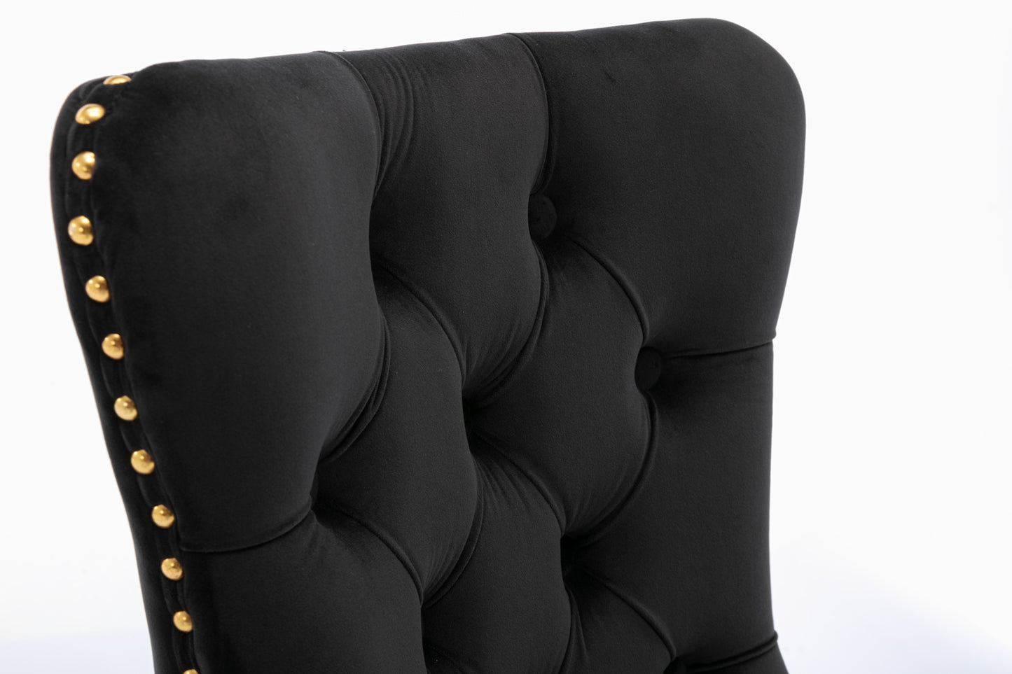 Black velvet tufted dining chair with gold nailhead trim accents