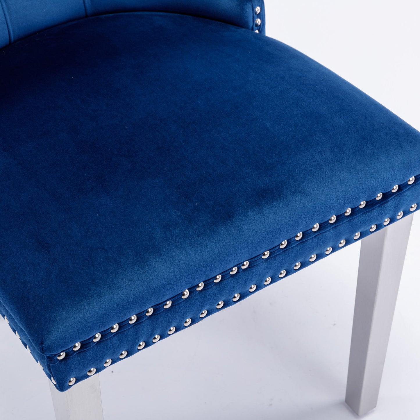 Deep blue velvet dining chair with silver nailhead trim and light gray legs