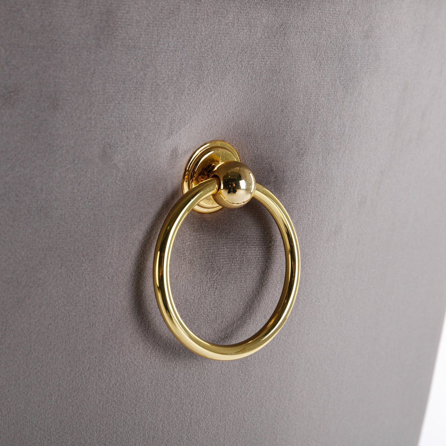 Gold ring pull on grey velvet upholstery