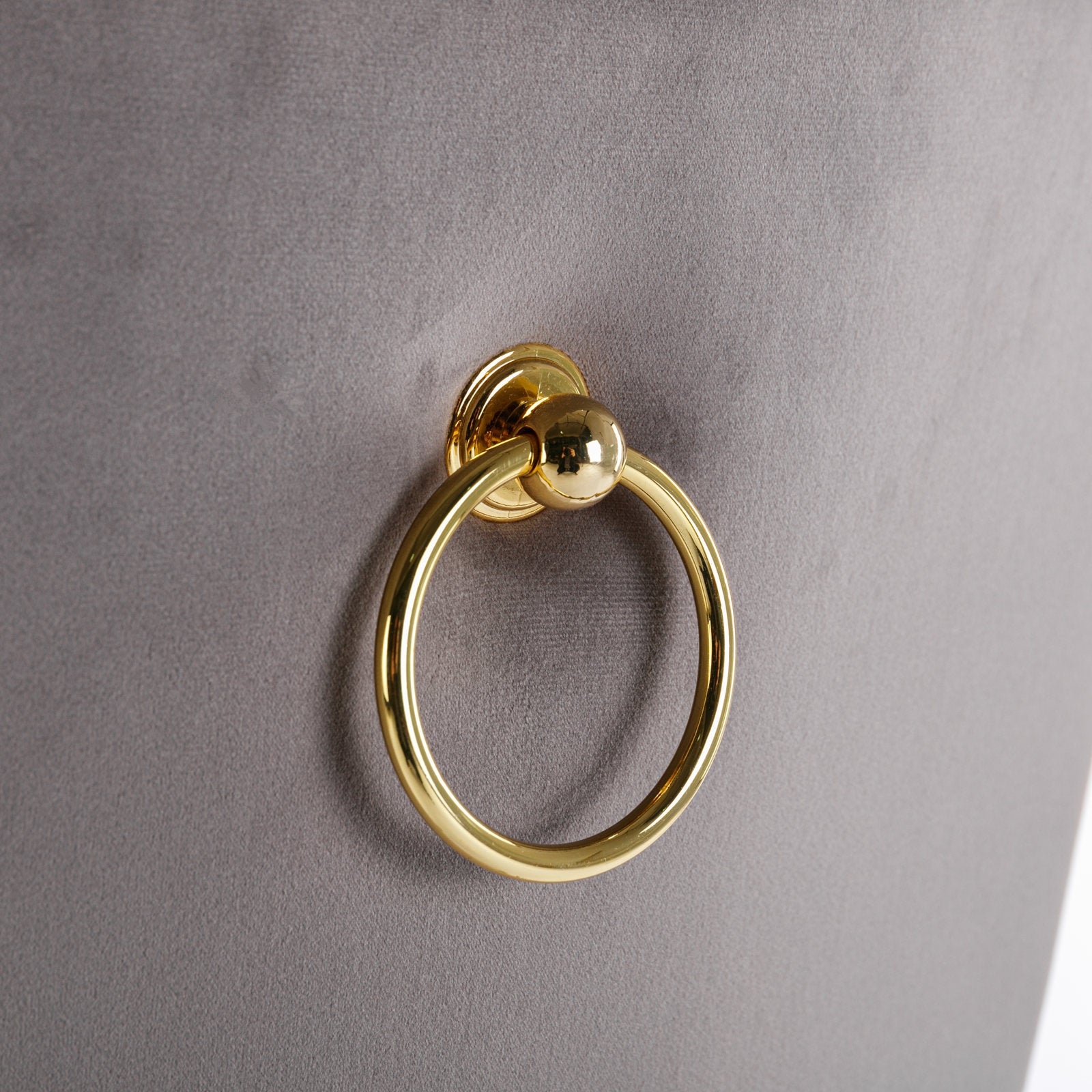 Gold ring pull on grey velvet upholstery