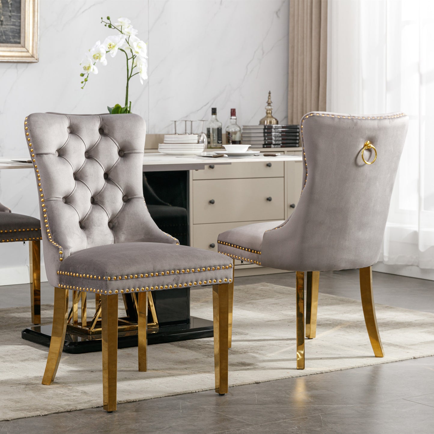 Tufted gray velvet dining chair with gold nailhead trim and brass legs