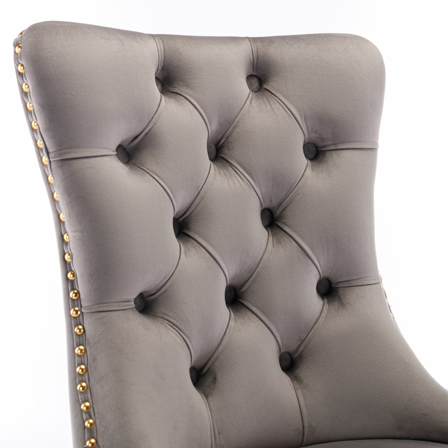 Gray velvet armchair back with diamond tufting and gold nailhead trim accents