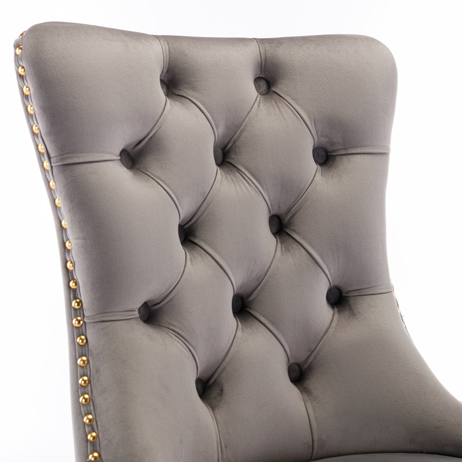 Gray velvet armchair back with diamond tufting and gold nailhead trim accents