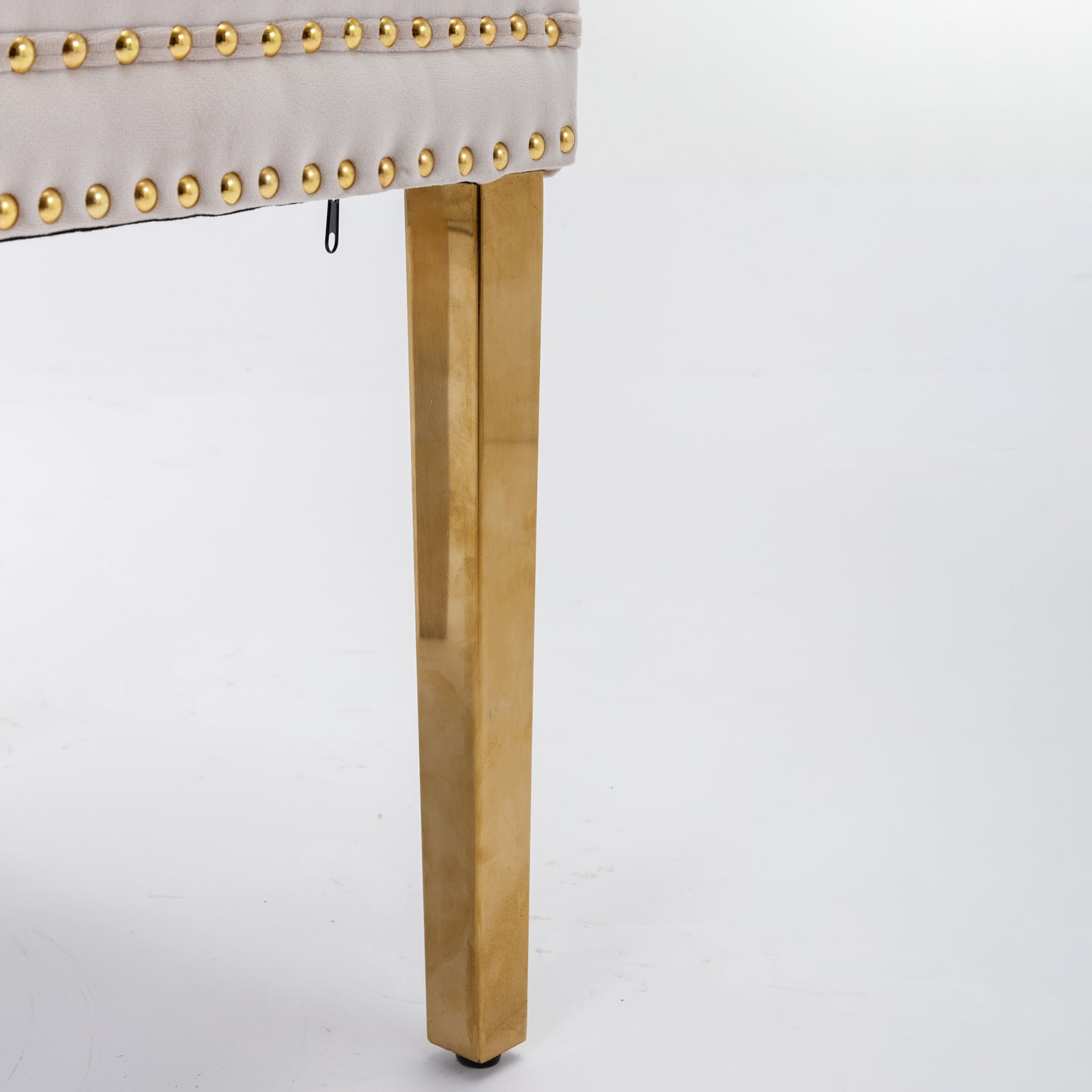 Light beige tufted ottoman with gold nailhead trim and modern gold leg