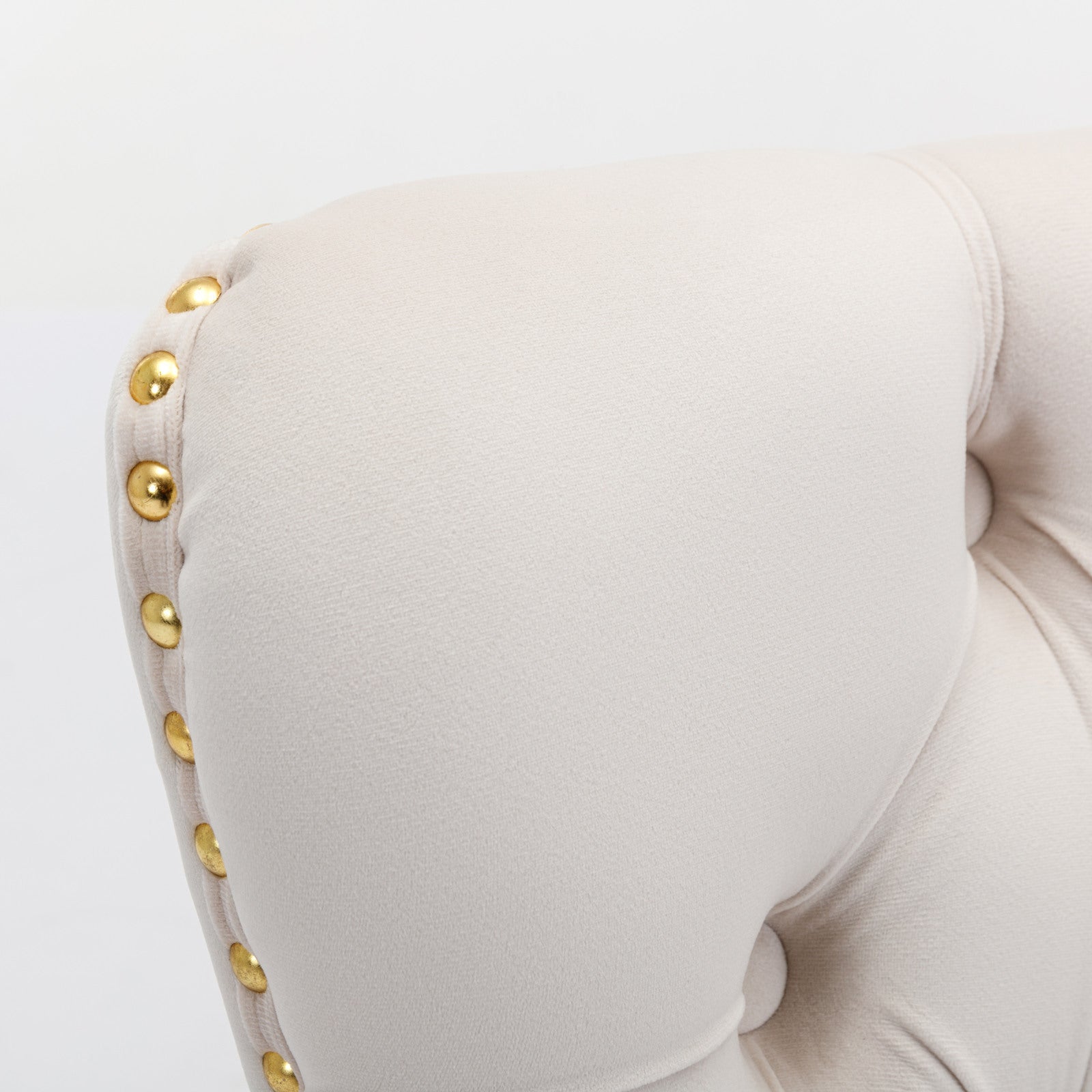Cream velvet armchair detail with gold stud accents