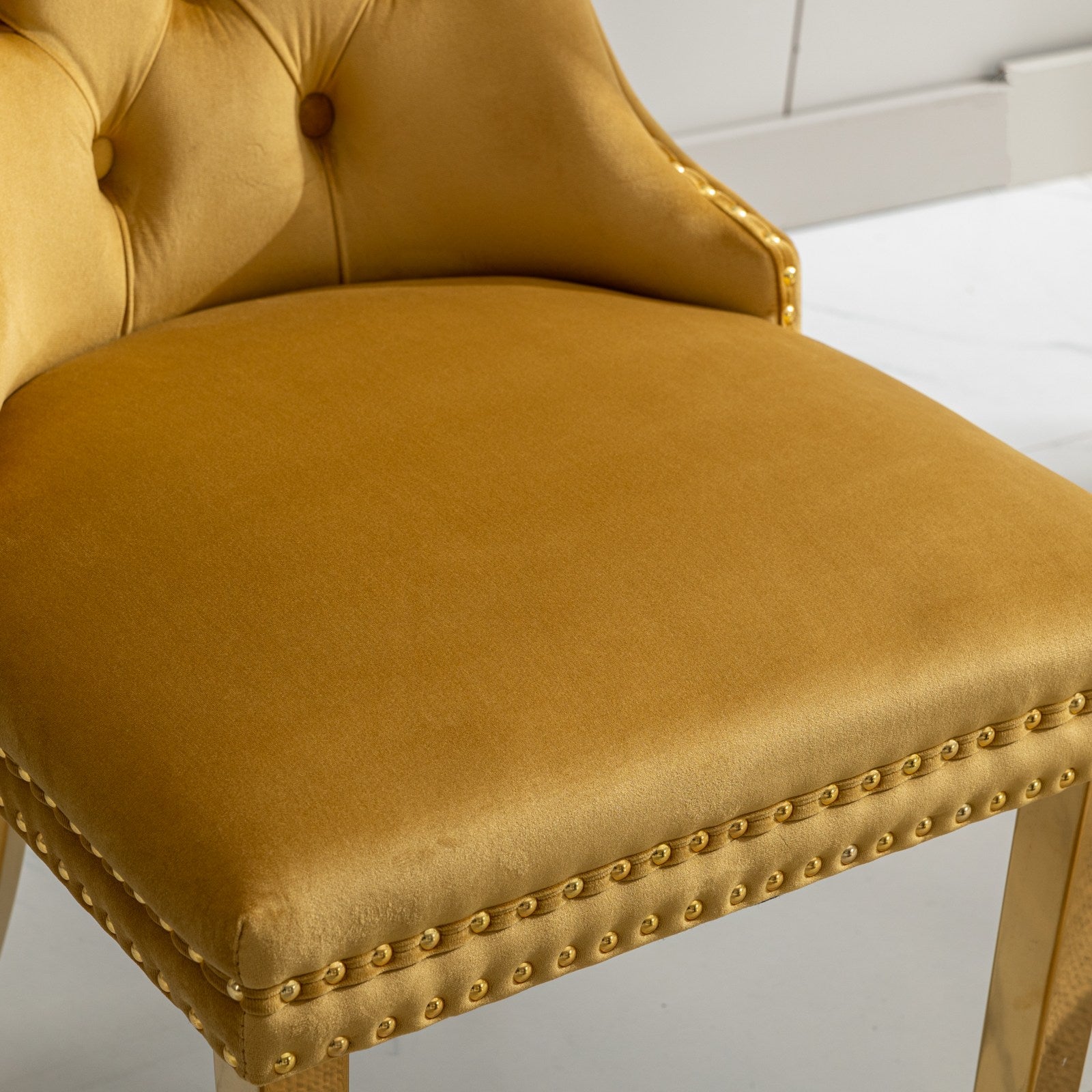 Tufted mustard velvet accent chair with gold nailhead trim and brass legs