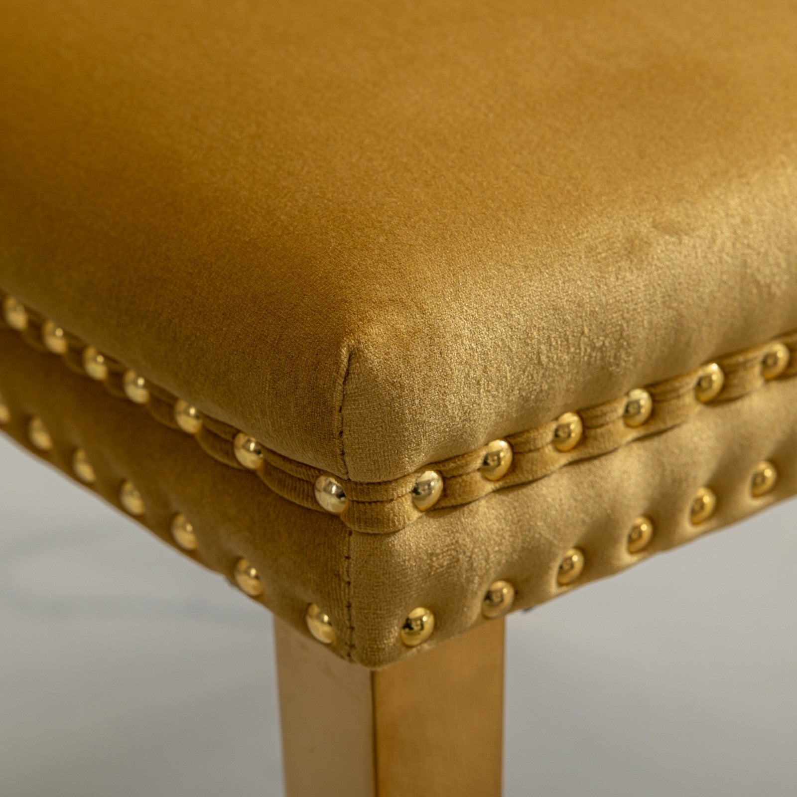 Gold velvet accent chair with brass nailhead trim
