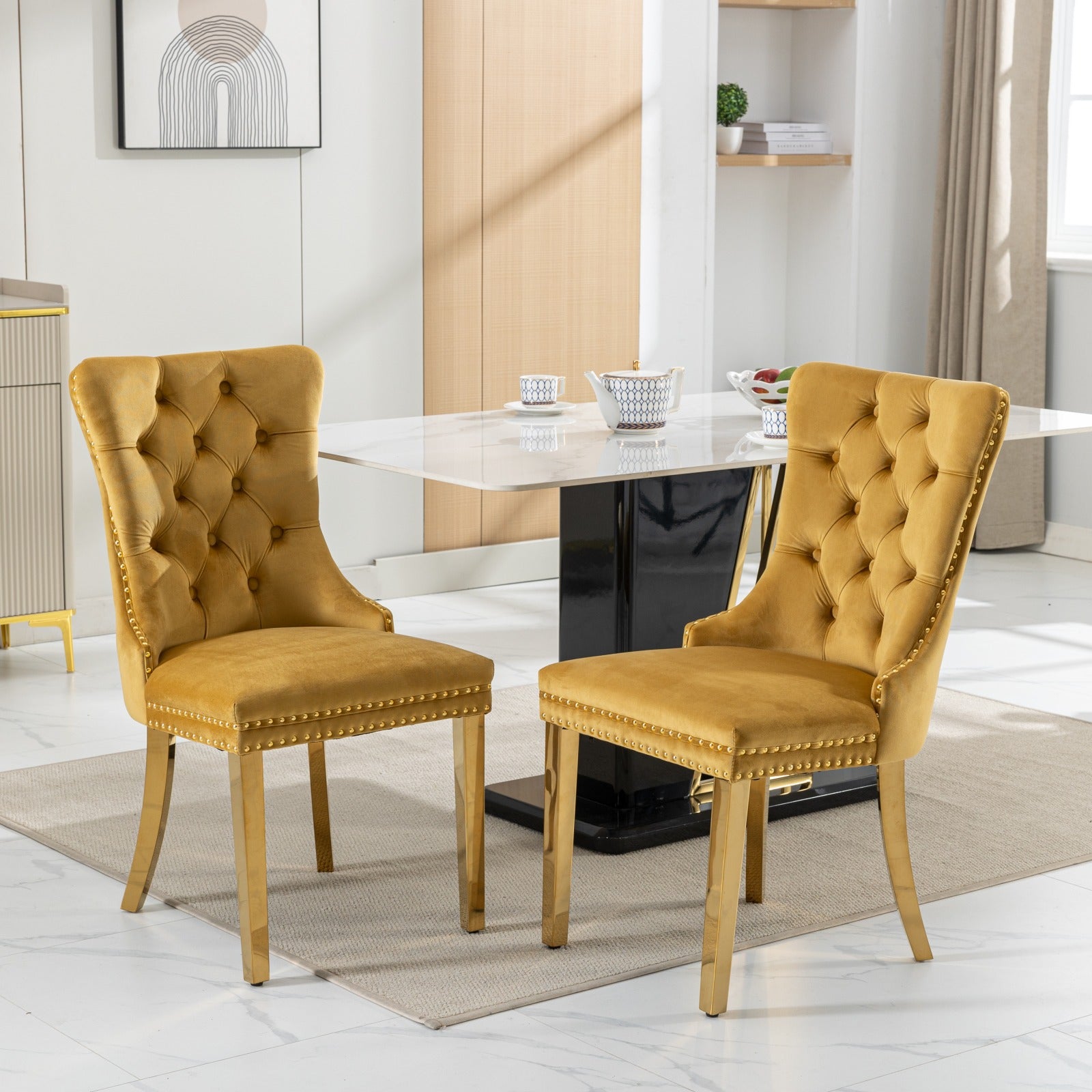 Mustard velvet dining chairs with gold accents and button tufting