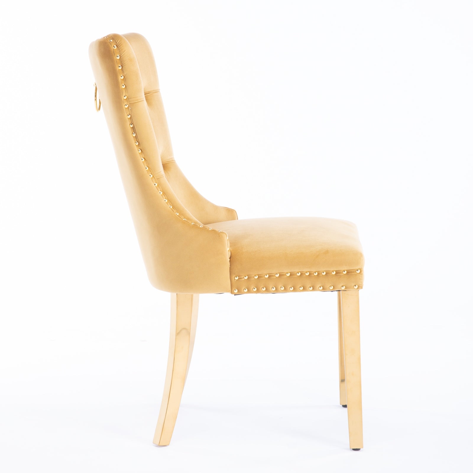 Gold velvet dining chair with button tufting and gold nailhead trim