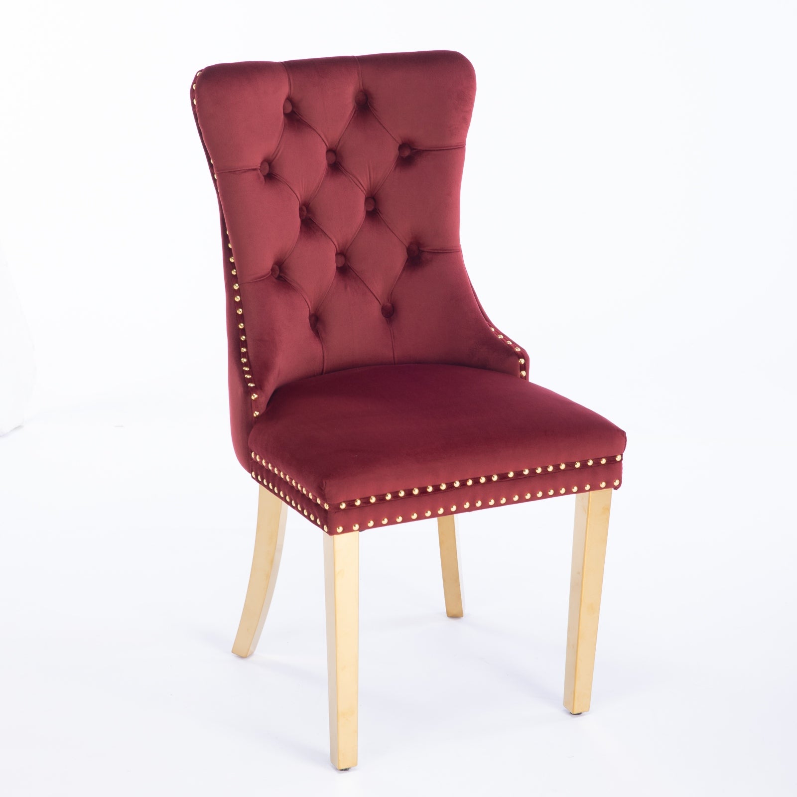 Deep red velvet dining chair with tufted back and gold nailhead trim