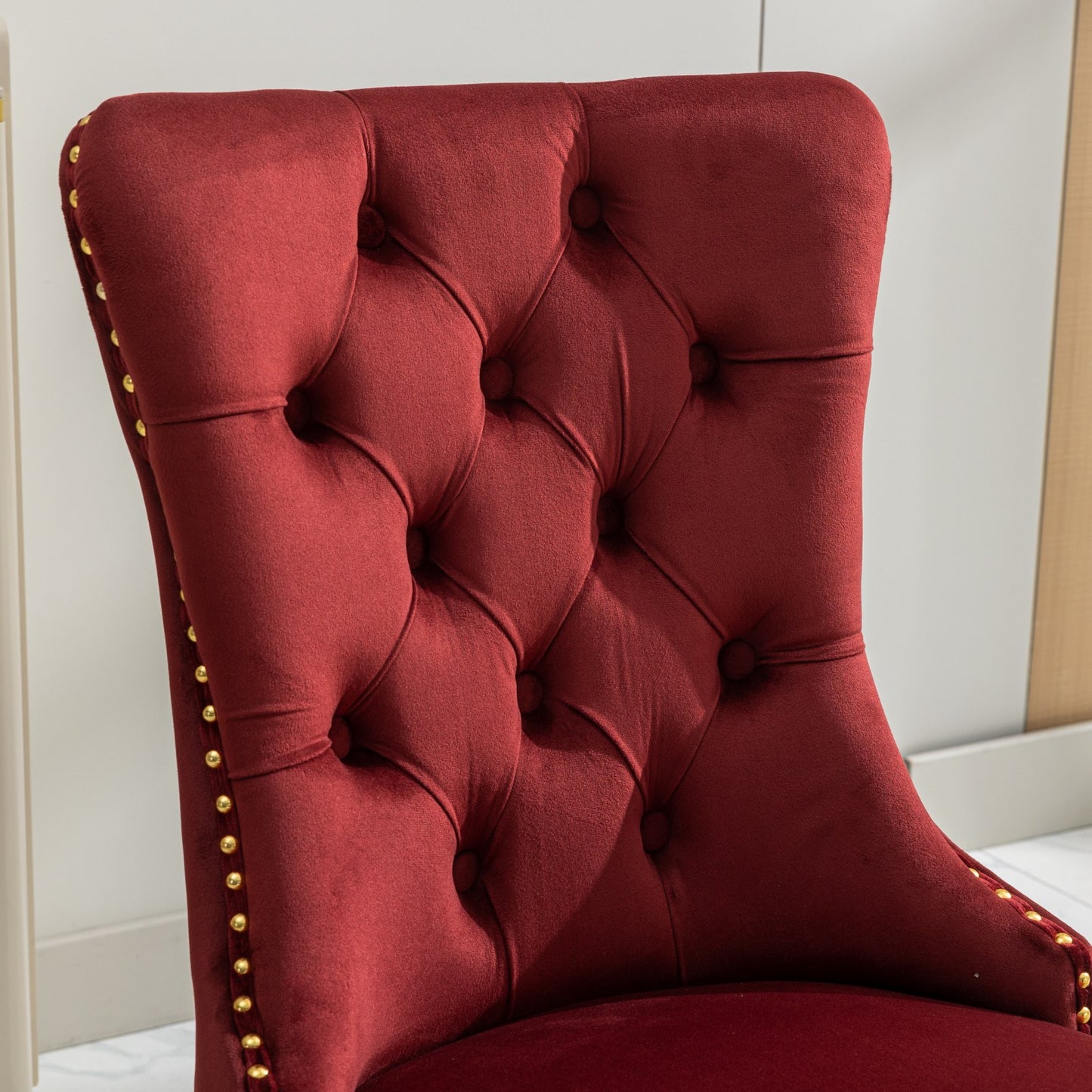 Burgundy velvet accent chair with diamond tufting and gold nailhead trim